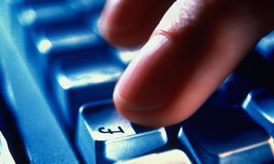 A finger hits the pound sign key of a computer keyboard